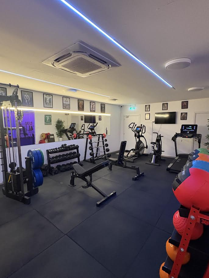 Main conditioning area with dumbbells, benches and cardio machines